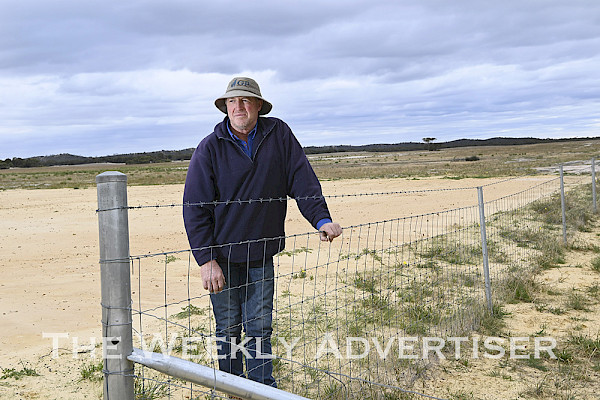INSPECTION: Farmer Alan Bennett inspects an exclusion fence on his property north of Yanac on the Big Desert Wilderness Park boundary.  Picture: PAUL CARRACHER