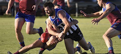 Minyip-Murtoa big man Tanner Smith manages to dispose of the ball under pressure from a Riley Williams tackle at Minyip on Saturday. The Burras held off a fast-finishing Horsham to win by nine points. Picture: PAUL CARRACHER